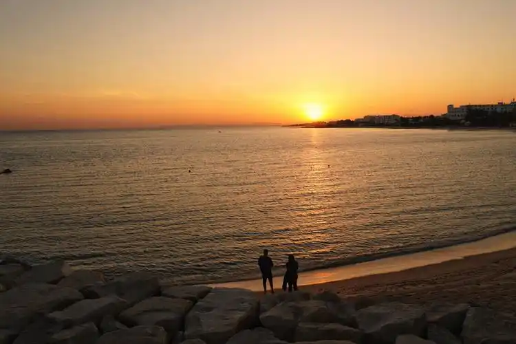 客人们在哈马马特的海滩欣赏落日余晖.