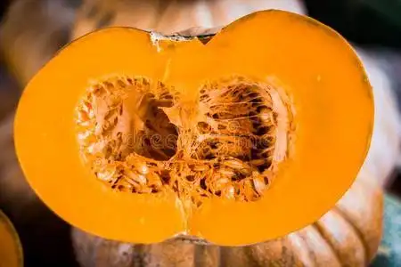 将切开南瓜显示为卖在蔬菜交易照片