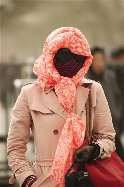 一名女子用围巾,口罩,太阳镜把头整个包住.