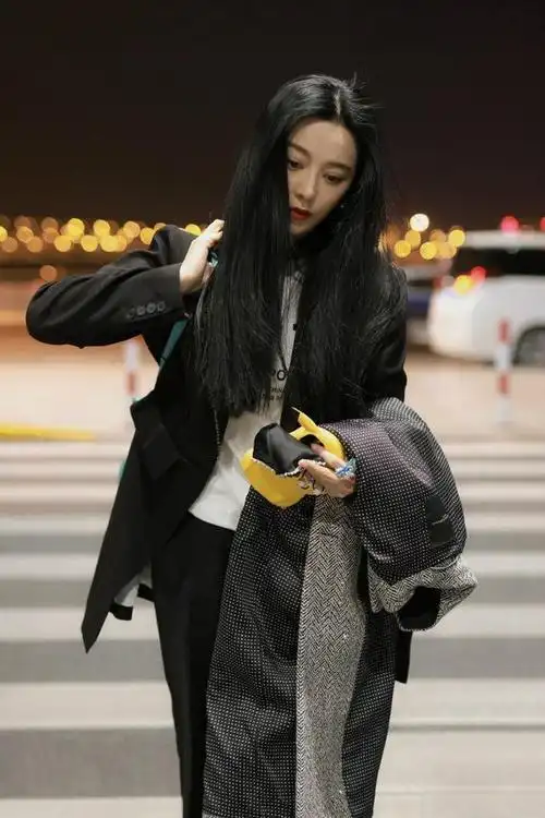 范冰冰机场真不嫌冷穿黑西装对镜头又美又飒大衣拿手里也不穿