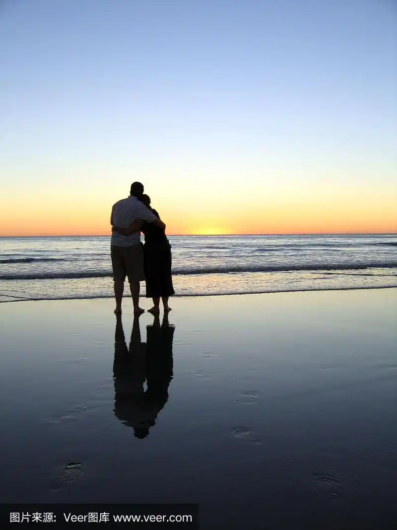 一对情侣在日落时分的海滩上拥抱