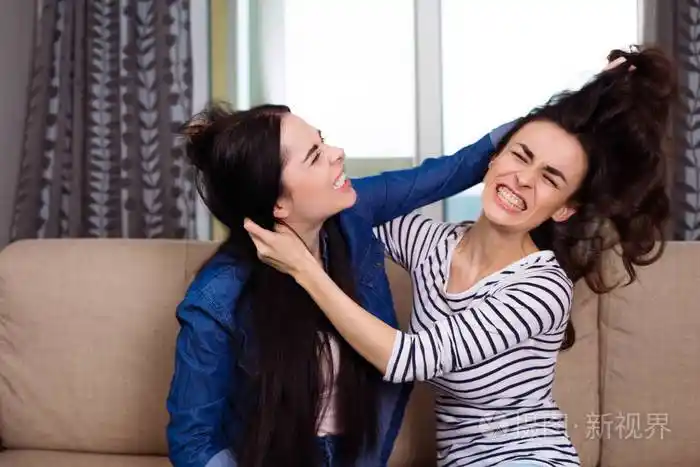 两个好斗的年轻女子打架互相抢夺头发