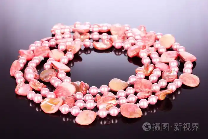灰色背景的粉红色珍珠项链和贝壳