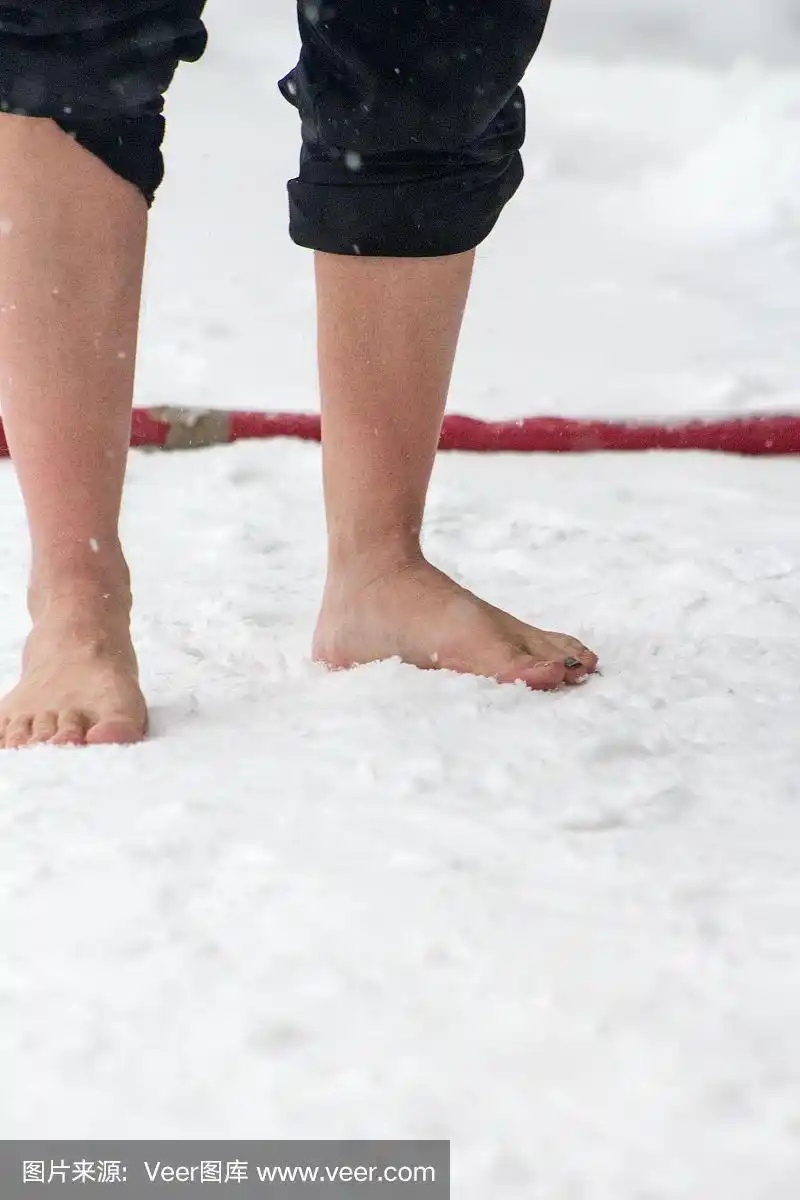 赤脚站在雪地里的白人男性