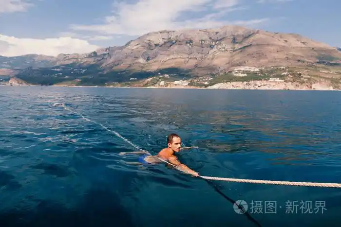 英俊的男人在大海里游泳照片-正版商用图片0wcc0n-摄图新视界