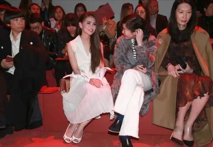 昆凌下身穿搭白色百褶裙,脚踩白色高跟凉鞋,优雅时尚.