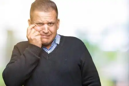 英俊的中年男子超过孤立的背景,看上去压力和紧张,双手咬嘴指甲.