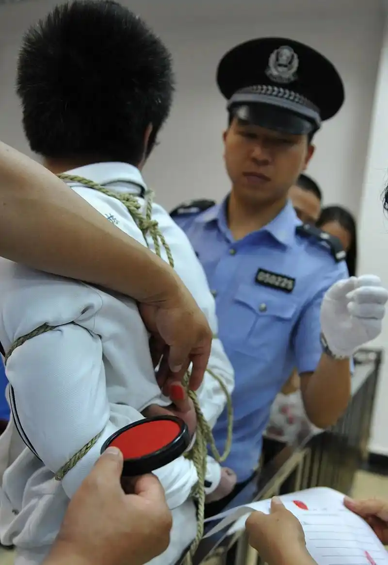 2012年,将被执行死刑的林文栋,画面中的他正在听从法警的安排,用捆绑