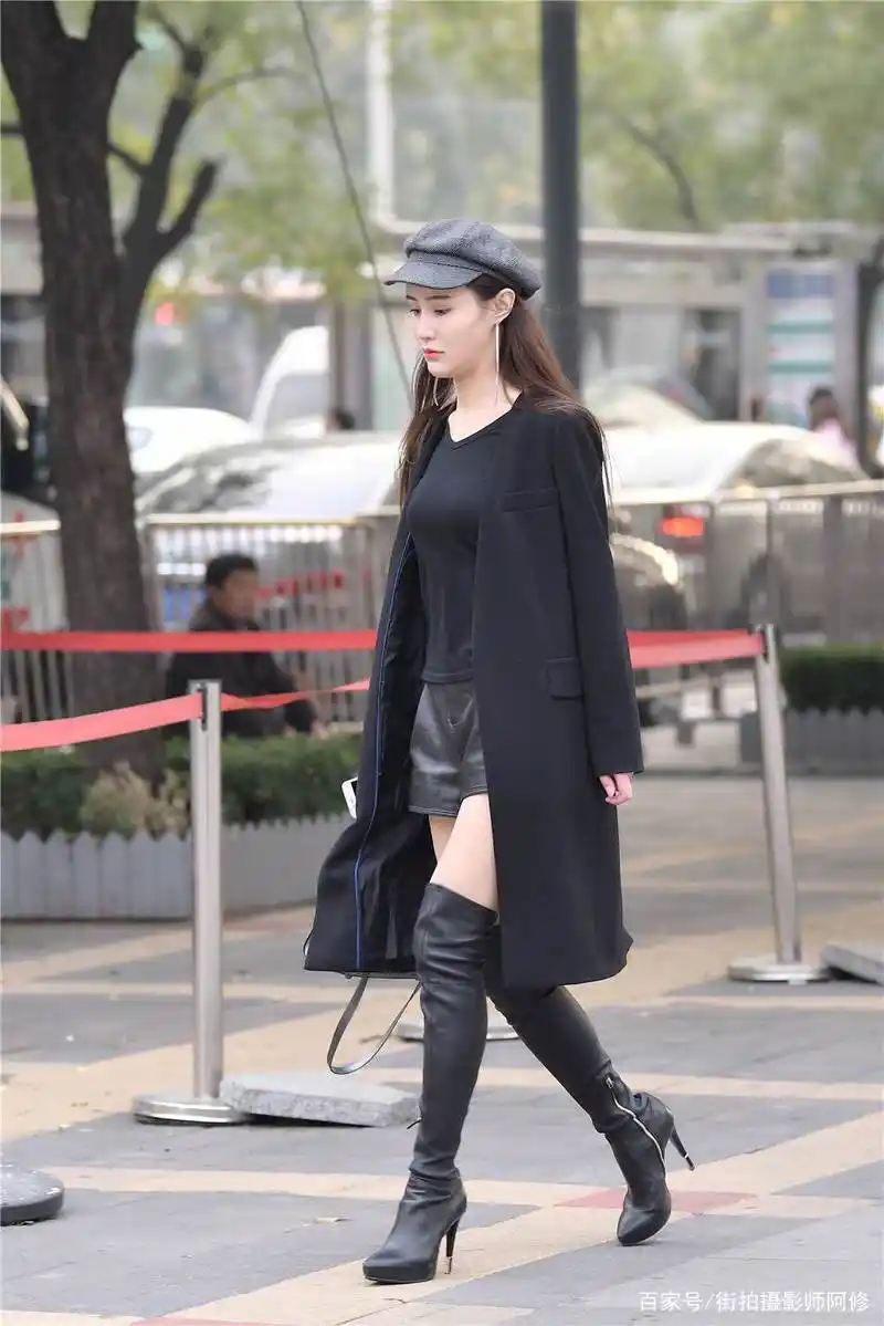 黑色细高跟过膝长靴,修身款式,搭配黑色风衣,时尚抢眼