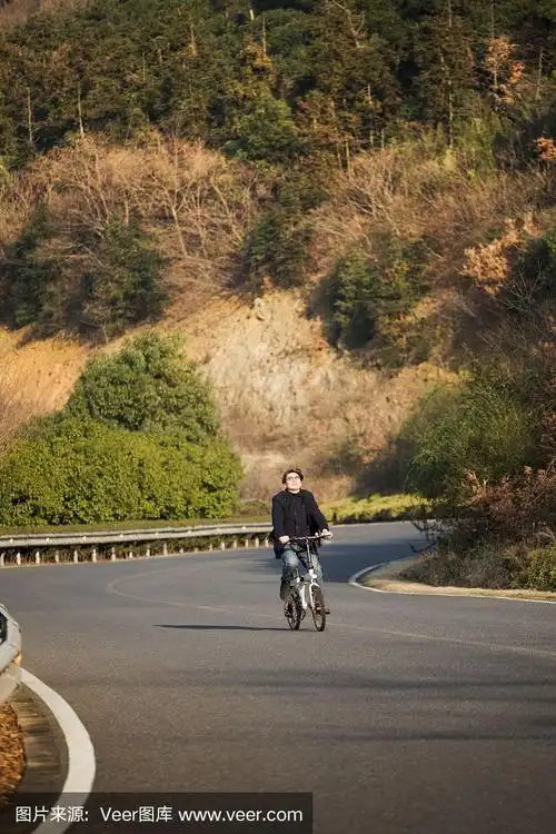 一个人骑着自行车沿着山区公路的远景