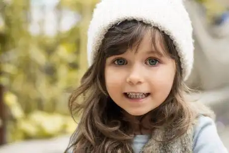 漂亮的小黑发女孩蓝眼睛一个可爱的小4岁小孩戴帽的户外肖像, 秋季