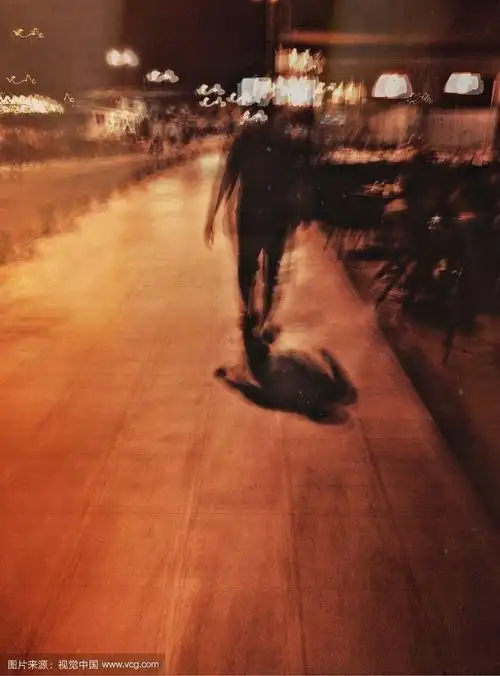 一个男人在晚上走在街上的模糊运动视图