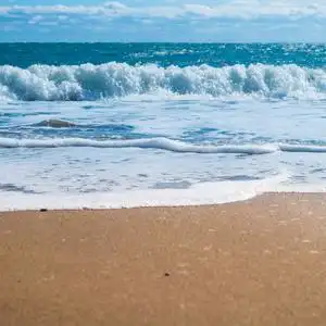 蓝色的大海和沙滩用金色的沙子照片