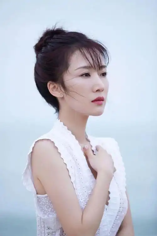 李念精致扎发淡雅妆容一袭白色长裙风吹发梢仙气飘飘