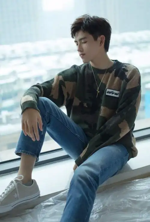 陈飞宇穿着军绿色针织衫,搭配简单款牛仔裤,脚上一双灰色运动