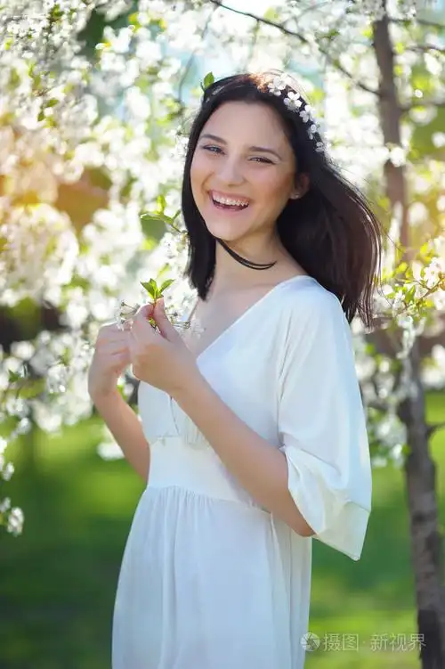 棕色的头发在春天公园笑幸福女人