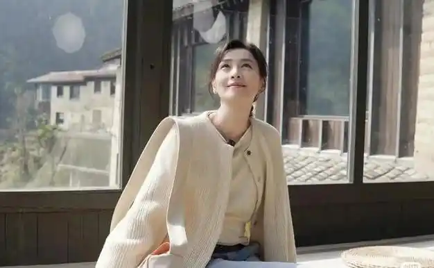 54岁张庭状态超好米色毛衣开衫搭配蓝色牛仔裤休闲时尚