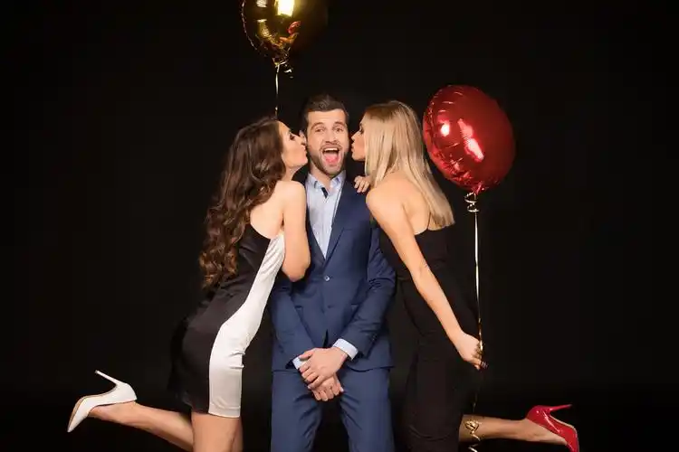 黑色背景上两个女性正在亲吻一位男性