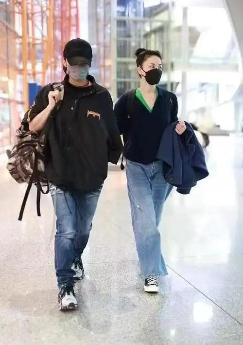 王菲牵谢霆锋走机场扎马尾像高中生小男友单手插兜扮酷