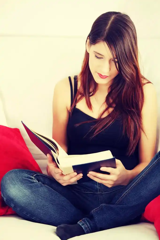 女人在看书,美丽的女人,读一本书,坐在客厅里的沙发上