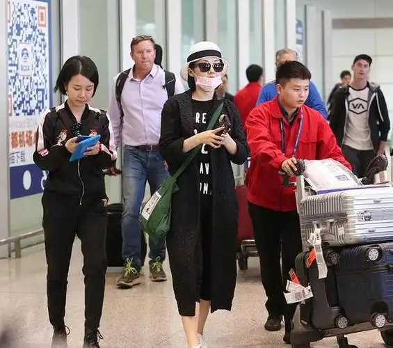 许晴全黑look与助理现身机场.口罩,帽子,墨镜全副武装显得低调干练