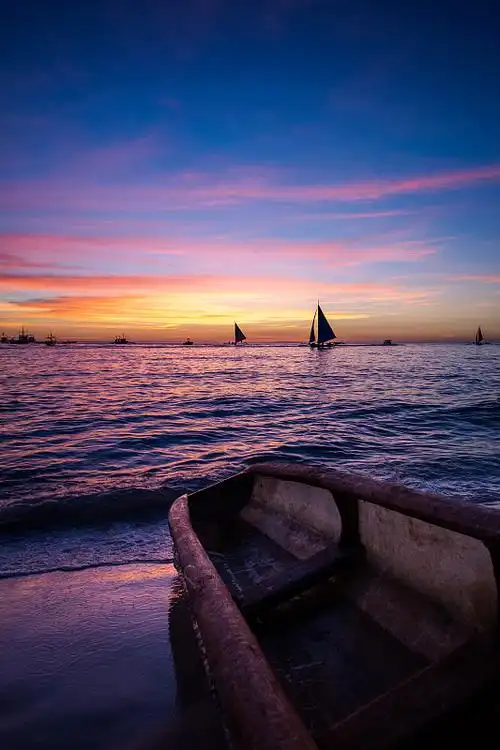 日落下的海洋和帆船图片