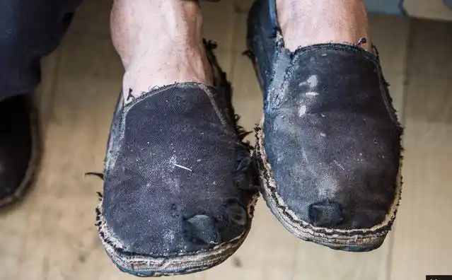 一名村民的双脚上老布鞋已经布满了补丁.