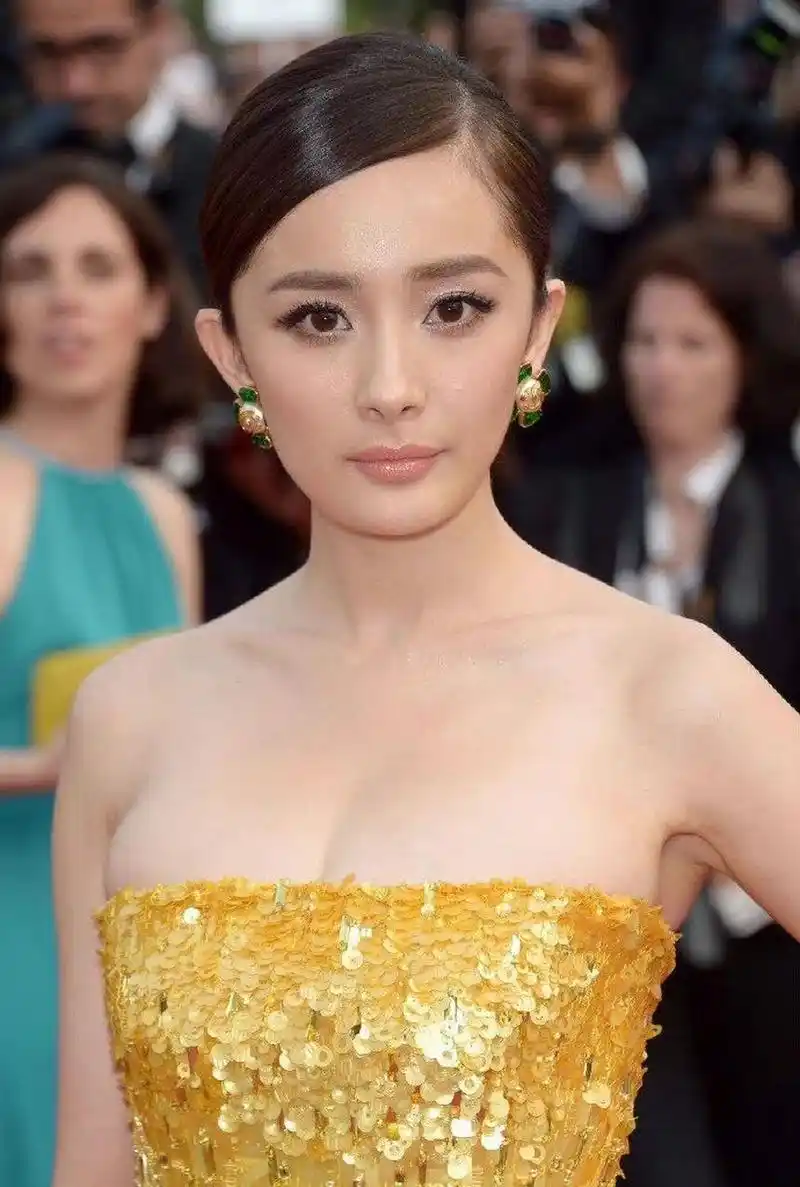 杨幂身穿露肩抹胸礼服,女人味爆棚  在照片中,杨幂身穿一件亮黄色的