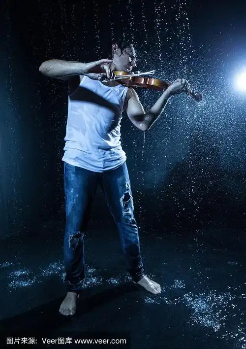 穿着牛仔裤的音乐家男孩在雨中拉小提琴