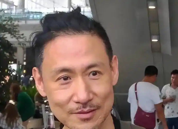 镜头中,张学友梳着背上的头发.胡子好像很久没梳了.