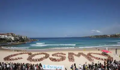 身着比基尼泳装的美女们在悉尼邦迪海滩摆出著名时尚杂志《cosmo〉哪