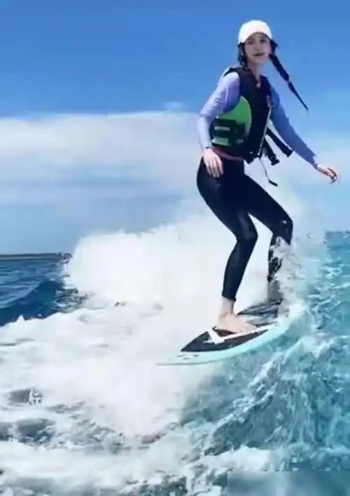 baby冲浪的姿势也非常熟练帅气,即使浪很高也能耍帅,还有心情对镜头摆