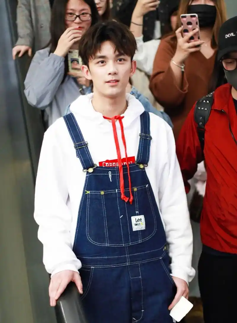 吴磊穿白色卫衣搭配背带裤现身上海机场过安检