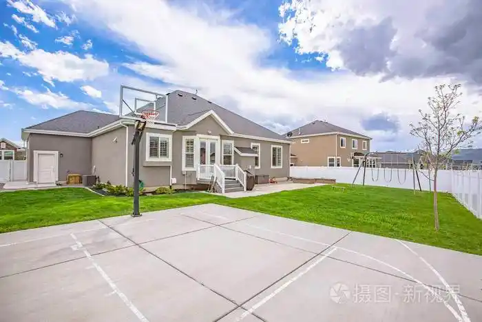 篮球场和秋千在一个单层家庭住宅宽敞的院子里