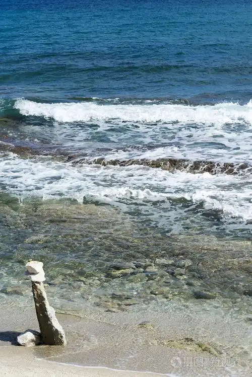 海浪在多石的海滩上,形成一朵浪花.波和溅上海滩.岩石上的海浪
