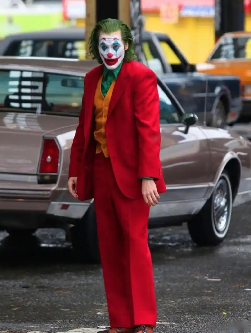 新版 《小丑》曝光全新片场照, 杰昆·菲尼克斯一身红色西装街头狂奔