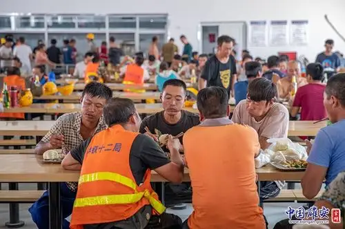 午饭时间,工人们一边吃着食堂为大家准备的家乡菜,一边侃侃而谈.