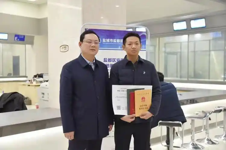 盐都区李益副区长手中接过了张庄街道"东晖锦园"安置房项目不动产权证