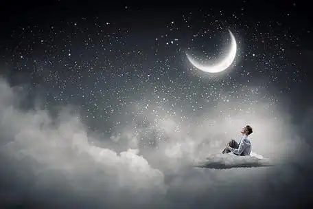 在夜空的商人穿西装坐在云上隔离,看着月亮的西装的商人