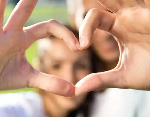 双手摆着爱心的情侣