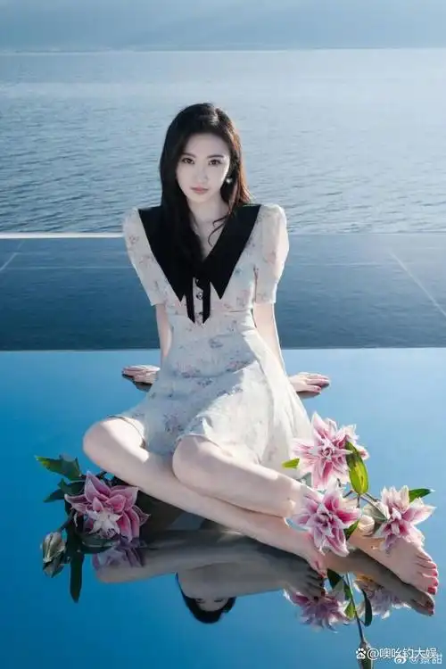 玉腿叠放有一种淑女的味道,景甜让花枝倚在自己的脚丫边,别有一番风味