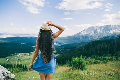 长头发的女人旅行山景观背视图中