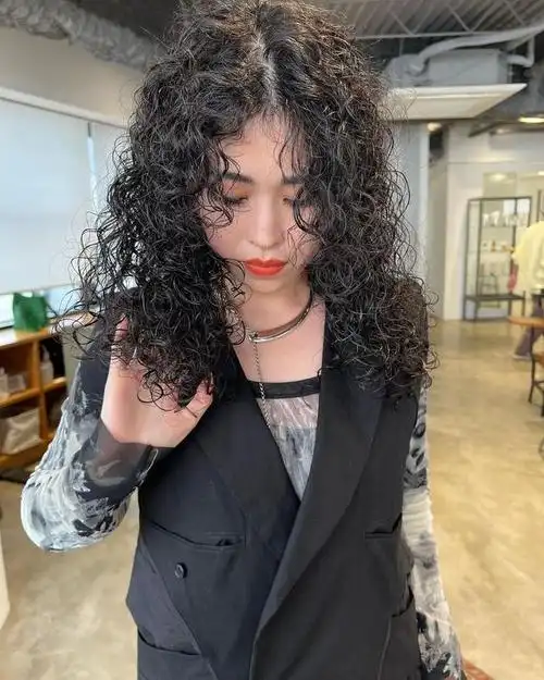 中分小卷发是一种充满活力和俏皮感的发型,适合日常生活或休闲场合.