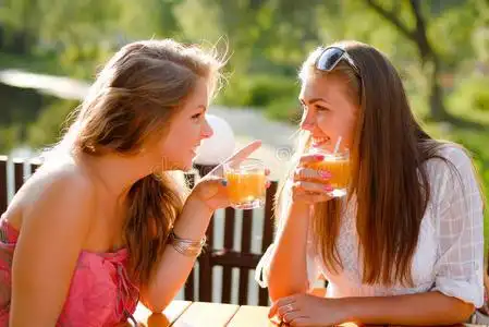 两个快乐的女朋友在露台咖啡厅聊天照片