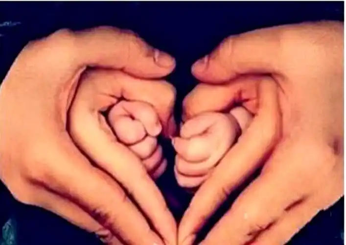 求一个图片,是一家三口用手摆出的心形,妻子用心形套小孩的手,丈夫在