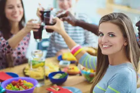 吃在飞机的女孩顶视图的一群人在一起时坐在木桌吃饭.在桌子上的食物.