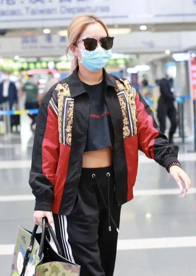王菊穿运动装走机场,慵懒造型太中性,抬起胳膊的瞬间却显女人味