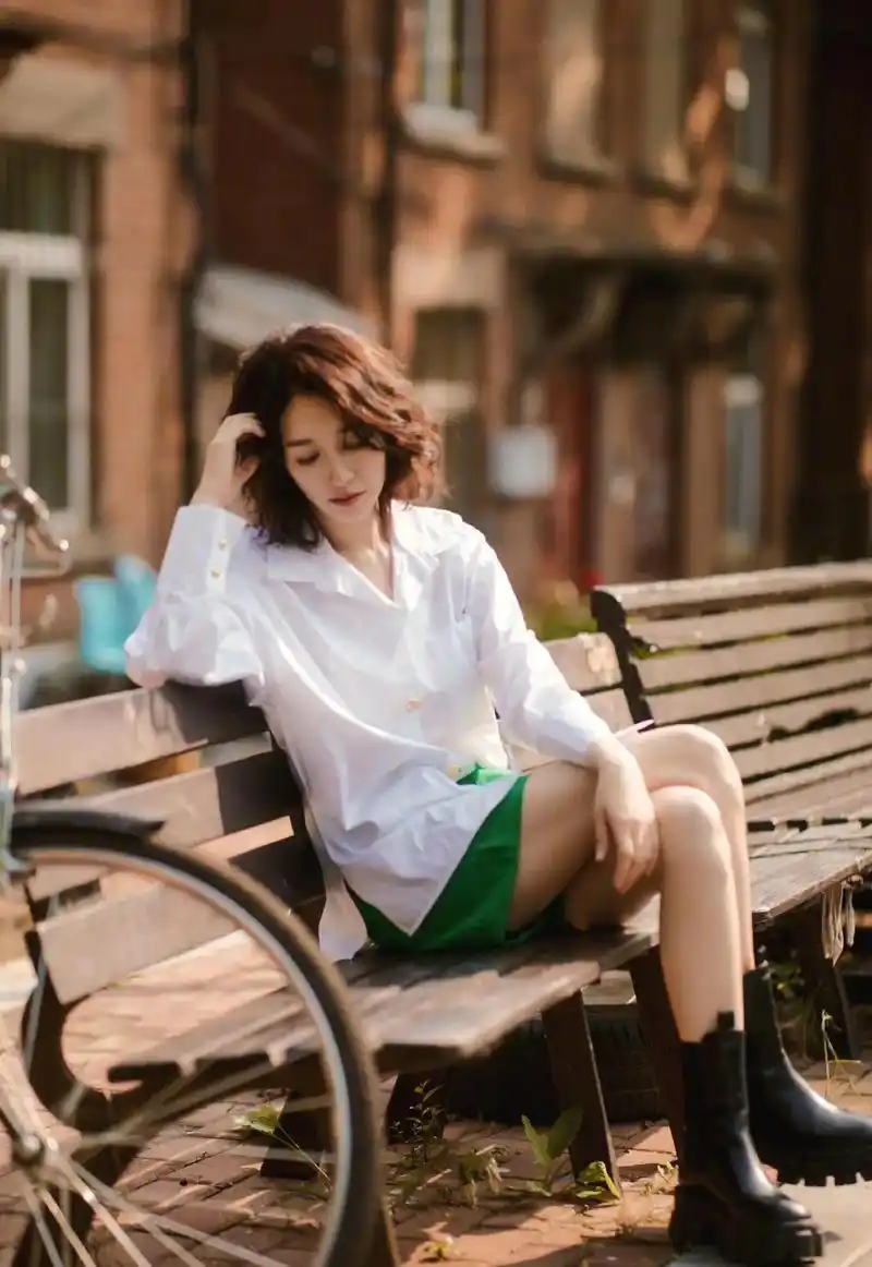 李小冉身穿一件白色衬衣一条绿色短裤一头蓬松的短发透着一股妖娆的