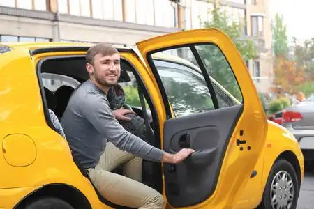 年轻人从出租汽车下车照片