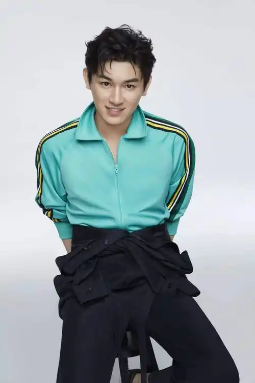 杨旭文写真图中,他身穿青色运动外套,搭配黑色连体衣,造型简约清新
